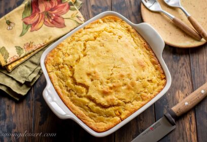 overhead view of a square casserole dish filled with hot corn pudding