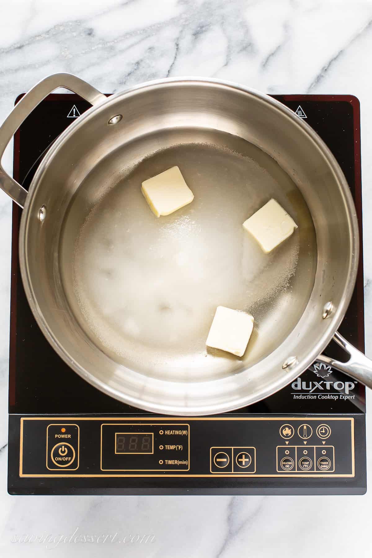 A saucepan with butter, water and sugar on a stovetop