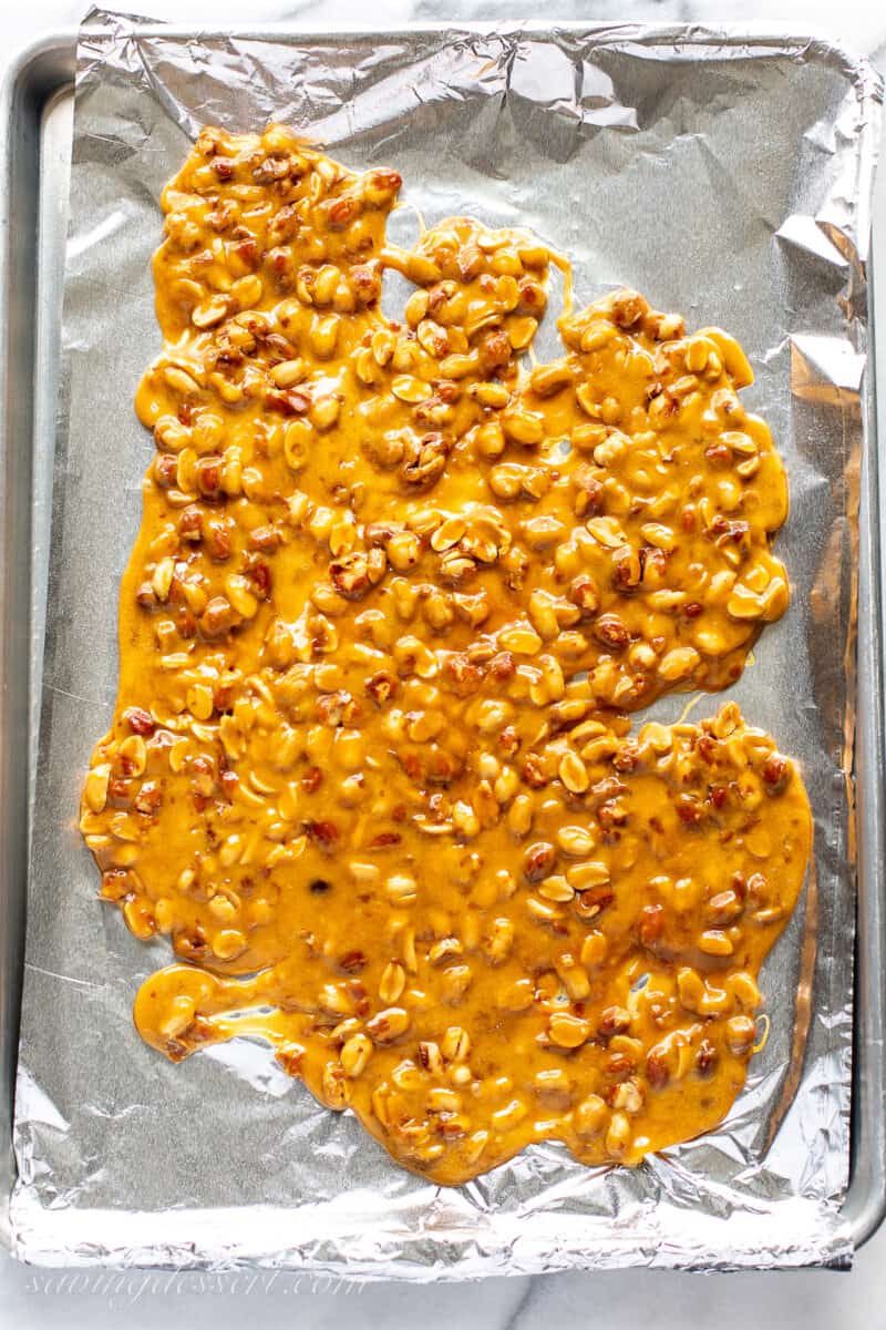 Peanut brittle spread on a foil lined baking sheet