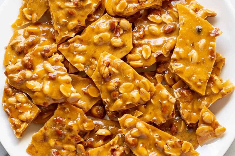 A plate filled with pieces of peanut brittle