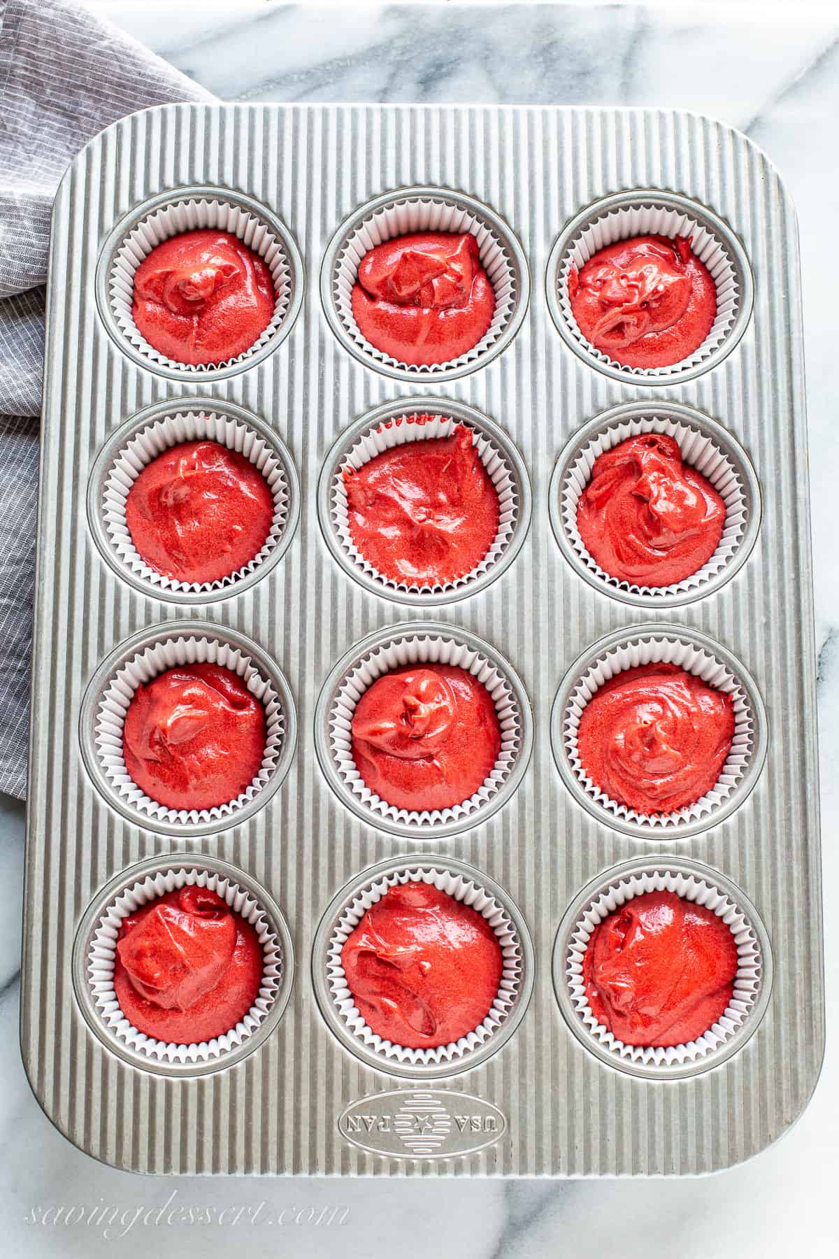 Red velvet batter divided between 12 muffin wells