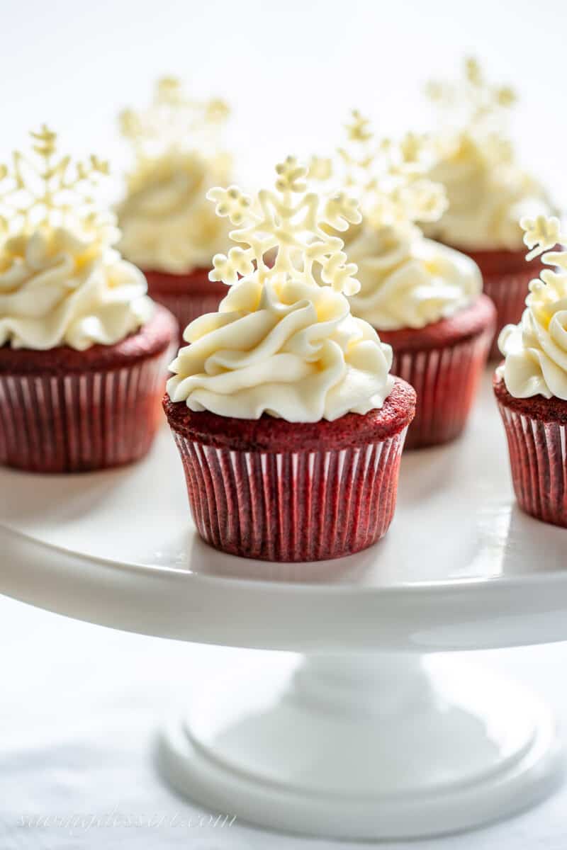 A side view of a cake platter filled with red velvet cupcakes