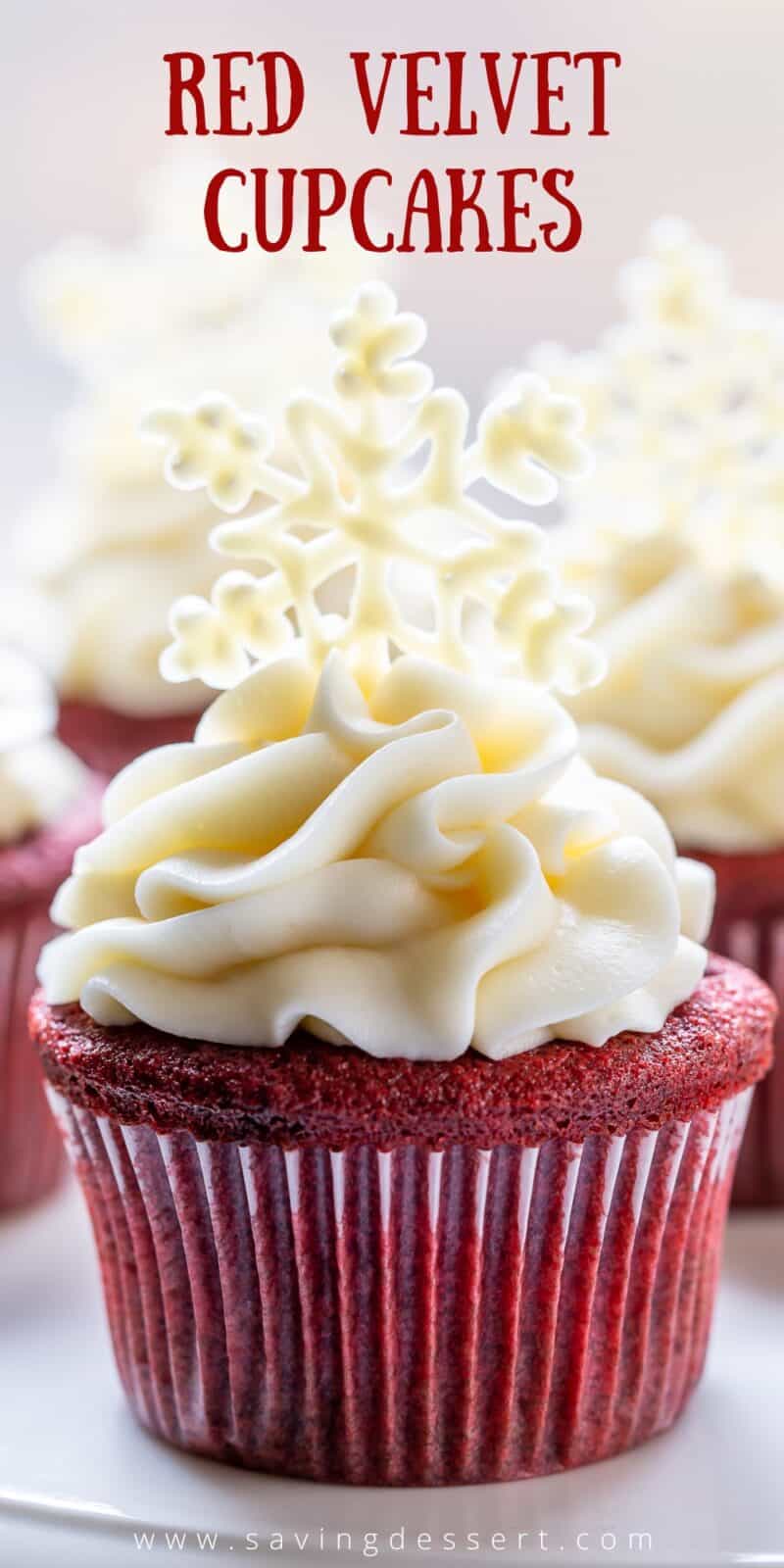 Closeup of a red velvet cupcake topped with cream cheese frosting and a white chocolate snowflake