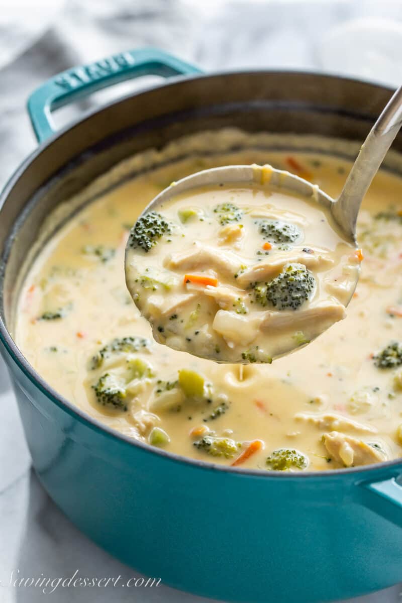 a ladle filled with cheesy broccoli soup