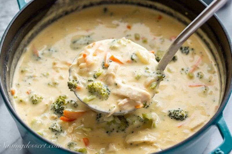 a ladle scooping out chicken broccoli soup from a pot