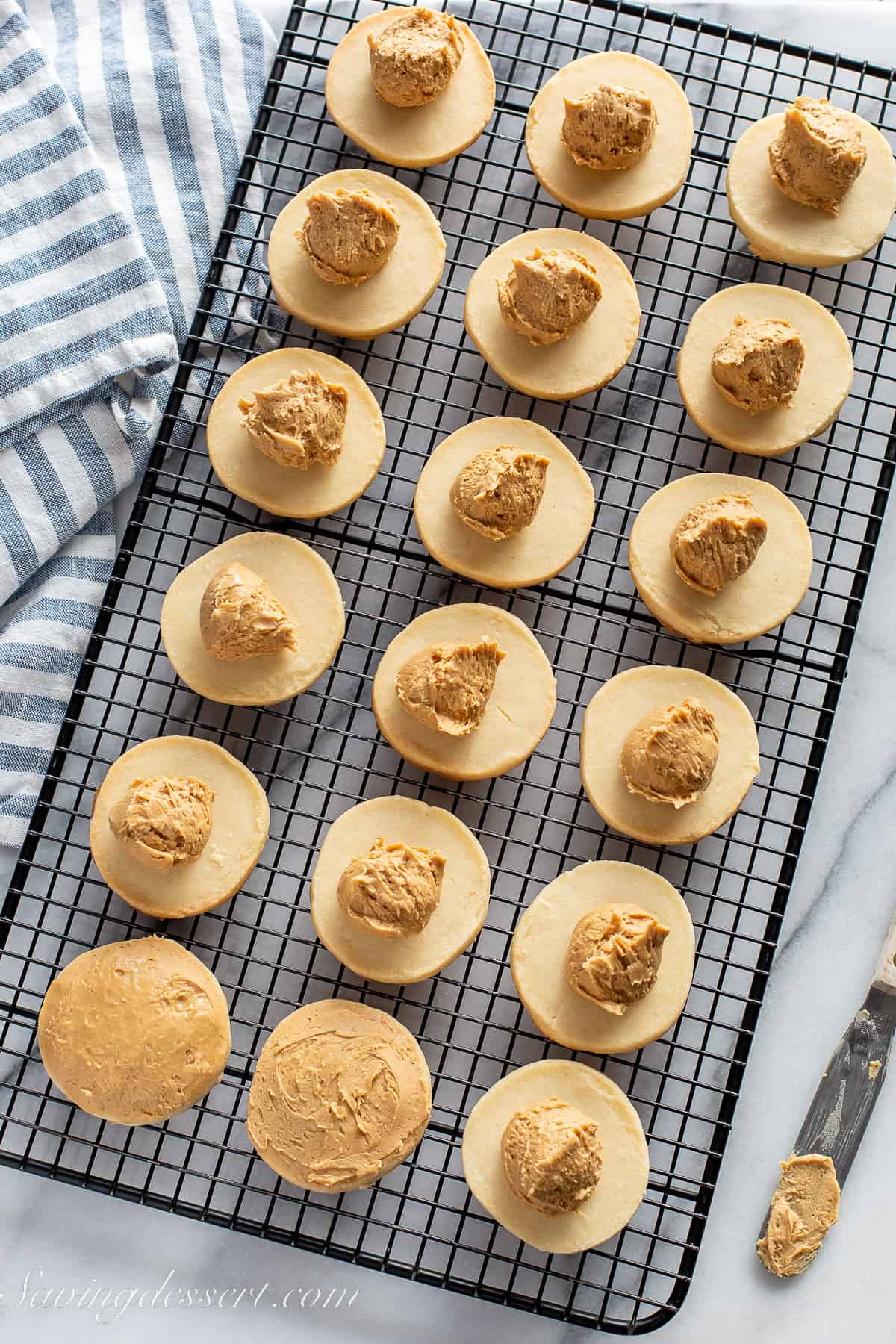 shortbread cookies on a cooling rack each with a scoop of a peanut butter mixture