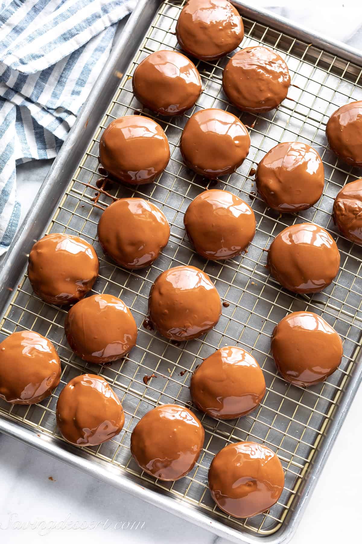 chocolate covered cookies on a cooling rack over a cookie sheet