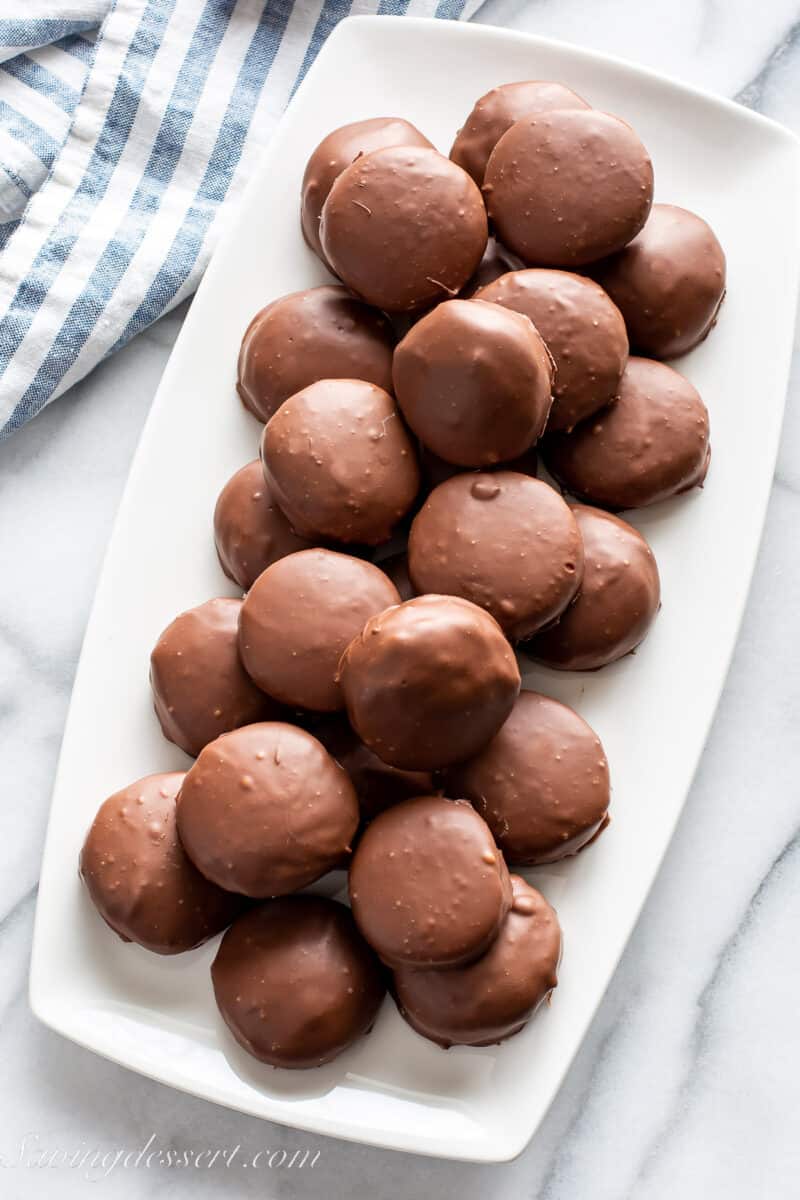 An overhead shot of a platter filled with Tagalongs - chocolate covered peanut butter shortbread cookies