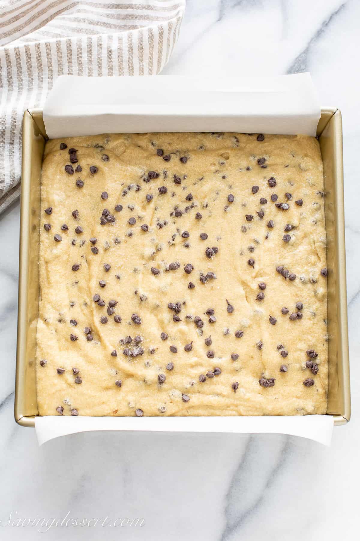 a square pan filled with chocolate chip banana cake batter