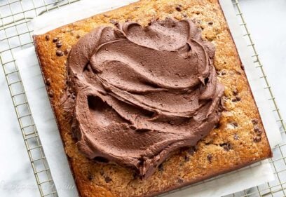 Overhead view of a square single layer banana cake topped with chocolate frosting