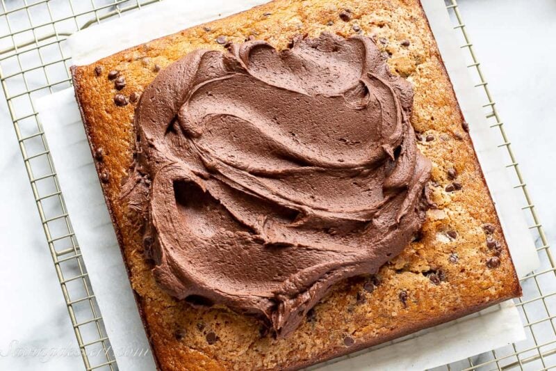 Overhead view of a square single layer banana cake topped with chocolate frosting