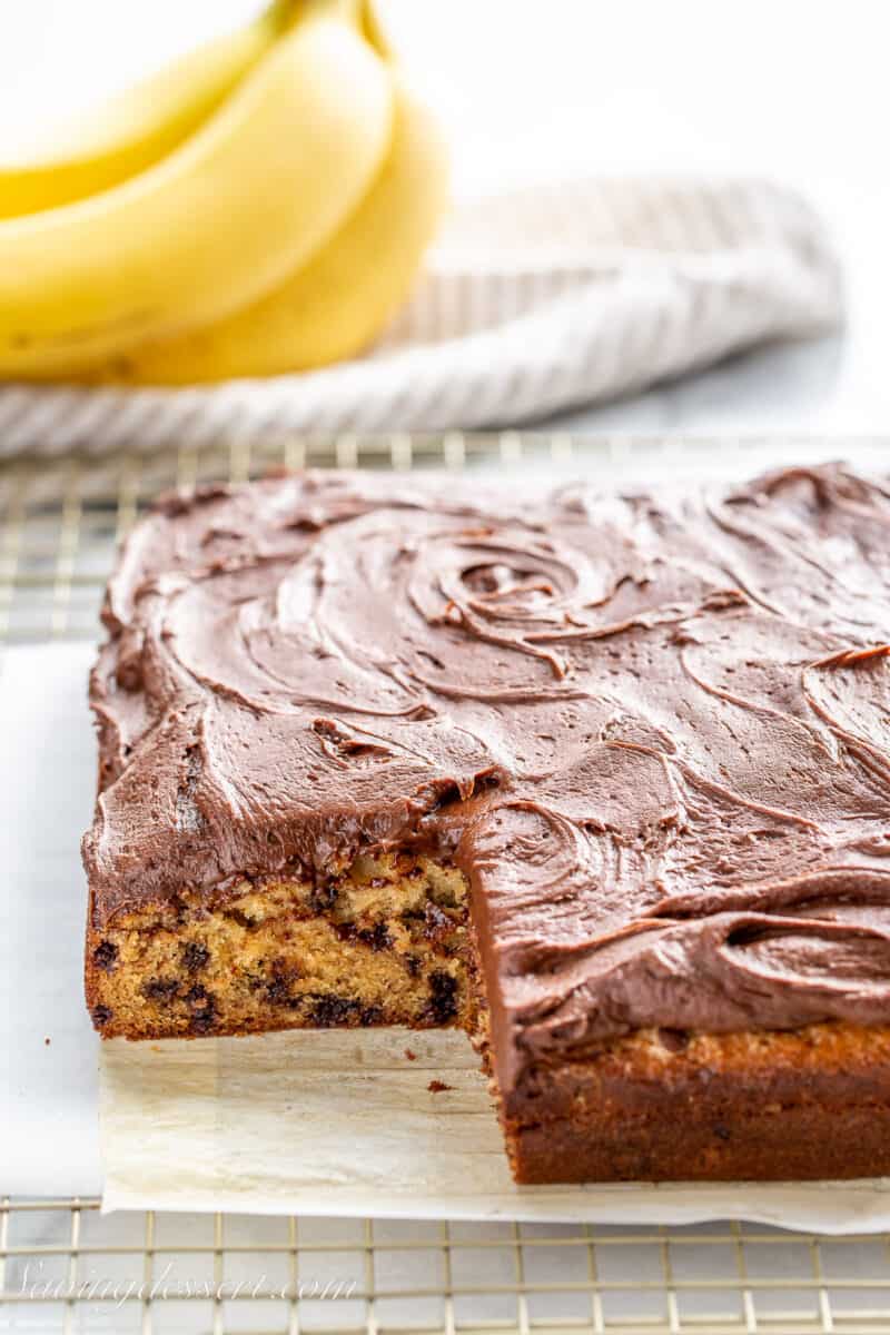 a sliced banana cake filled with chocolate chips and topped with chocolate frosting