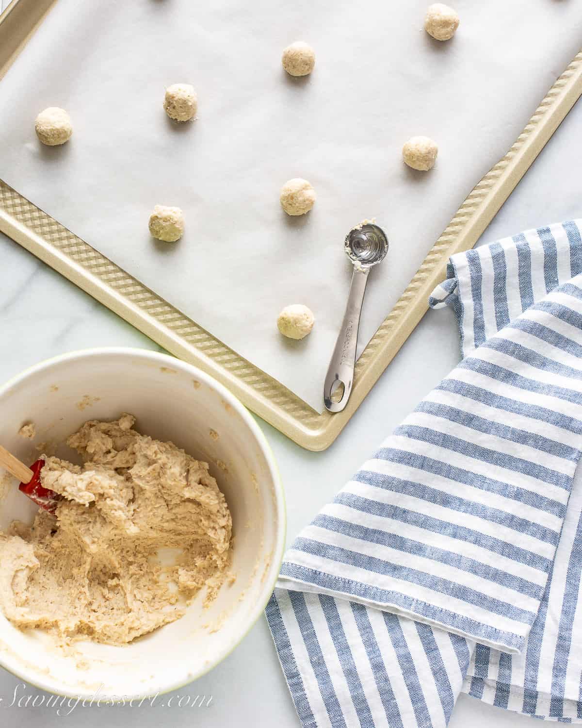 cookie dough being rolled into balls and placed on a baking sheet