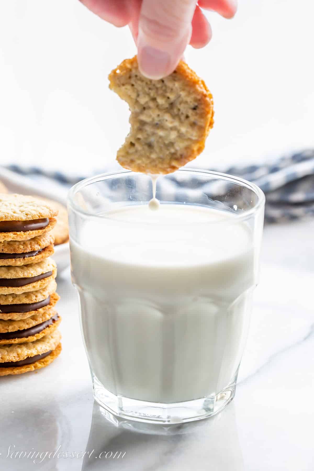 a cookie being dipped in a glass of milk