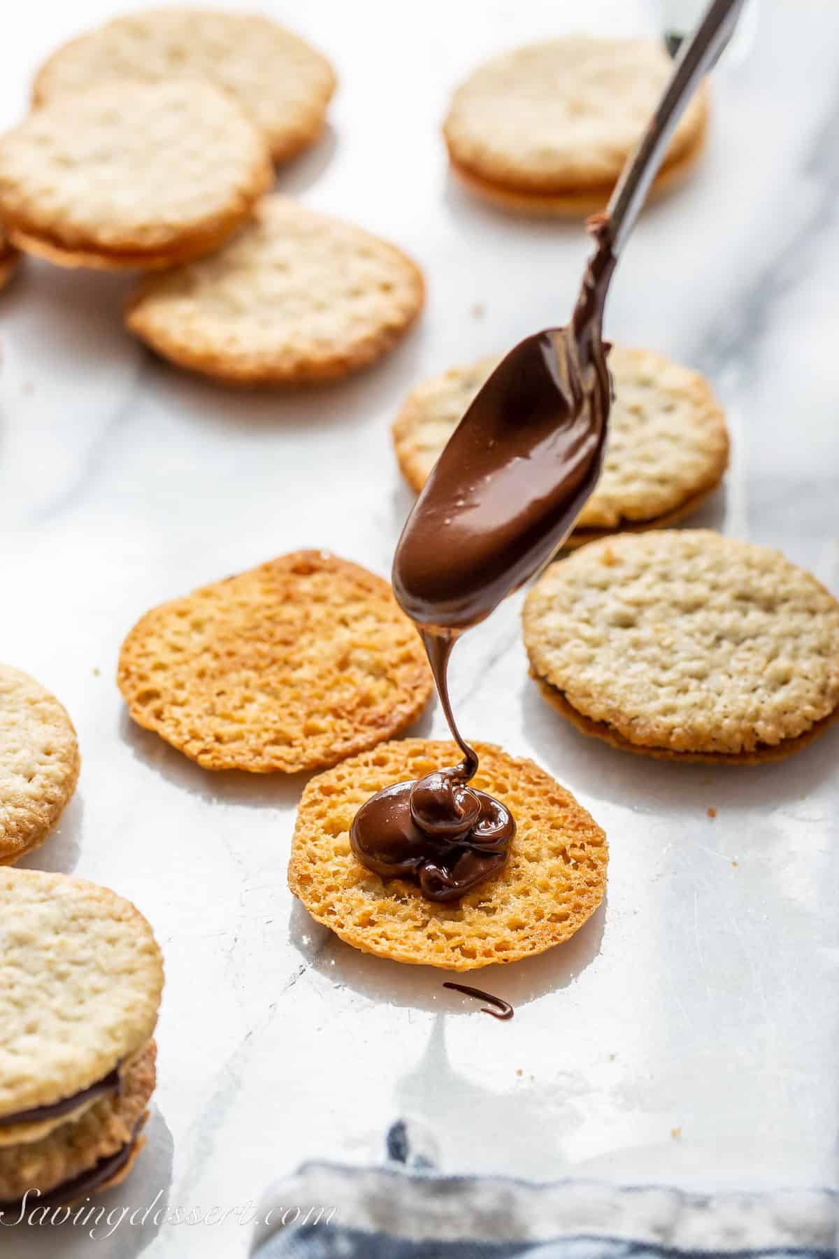 A Brussels cookie being filled with melted semisweet chocolate to make a sandwich