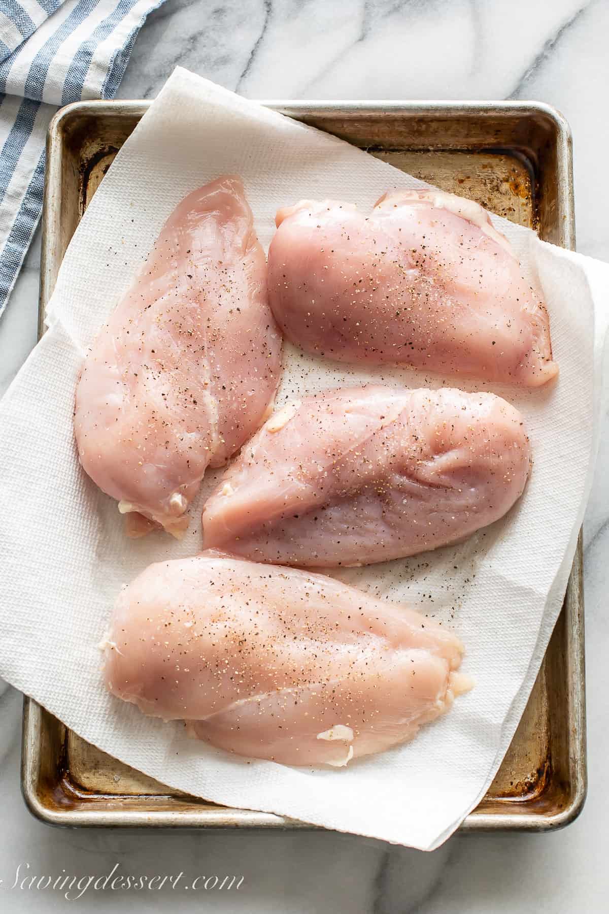 Chicken breasts on a tray lined with paper towels
