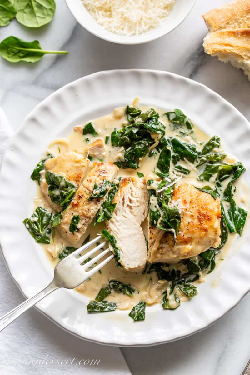 sliced chicken breast on a plate with a spinach cream sauce