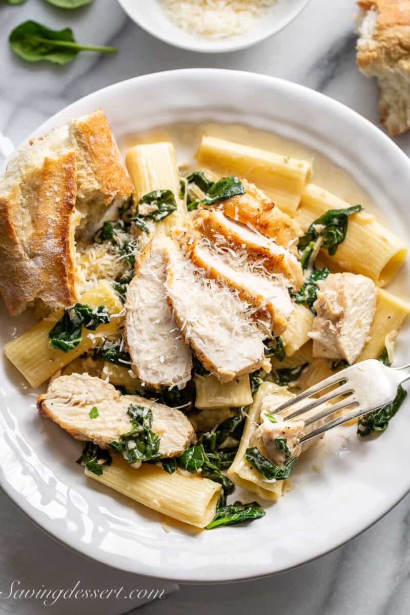 sliced chicken breast over pasta with a spinach cream sauce - chicken florentine pasta