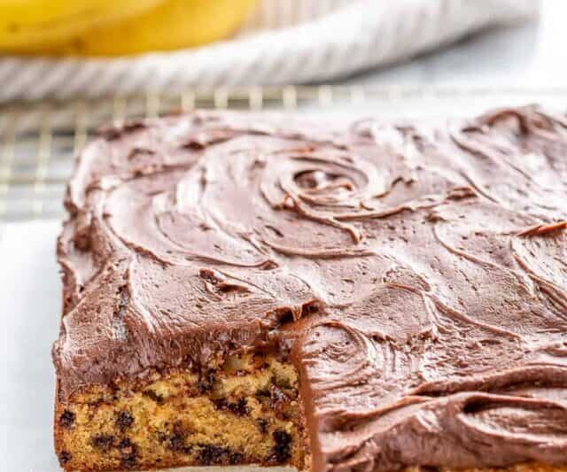 a sliced banana cake filled with chocolate chips and topped with chocolate frosting
