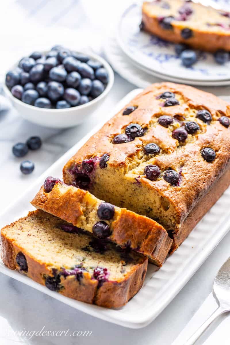 A sliced loaf of banana bread with blueberries