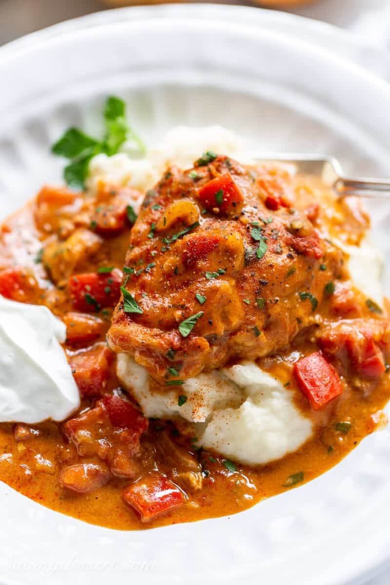 closeup of a piece of chicken paprikash over mashed potatoes