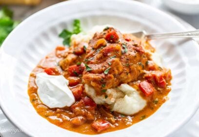 side view of a bowl filled with chicken paprikash over mashed potatoes