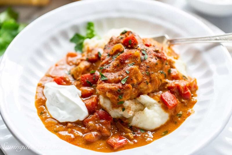 side view of a bowl filled with chicken paprikash over mashed potatoes