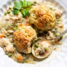 an overhead view of a bowl of chicken pot pie with herb biscuits on top