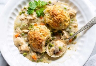 an overhead view of a bowl of chicken pot pie with herb biscuits on top