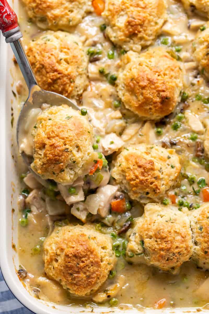 chicken pot pie with herb biscuits with a serving spoonful