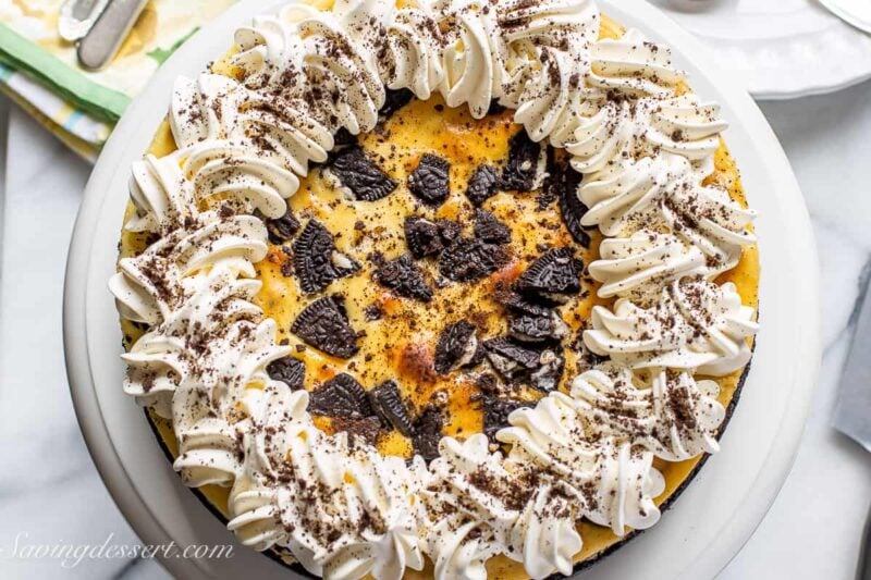 closeup of an oreo cheesecake decorated with whipped cream and oreo crumbs