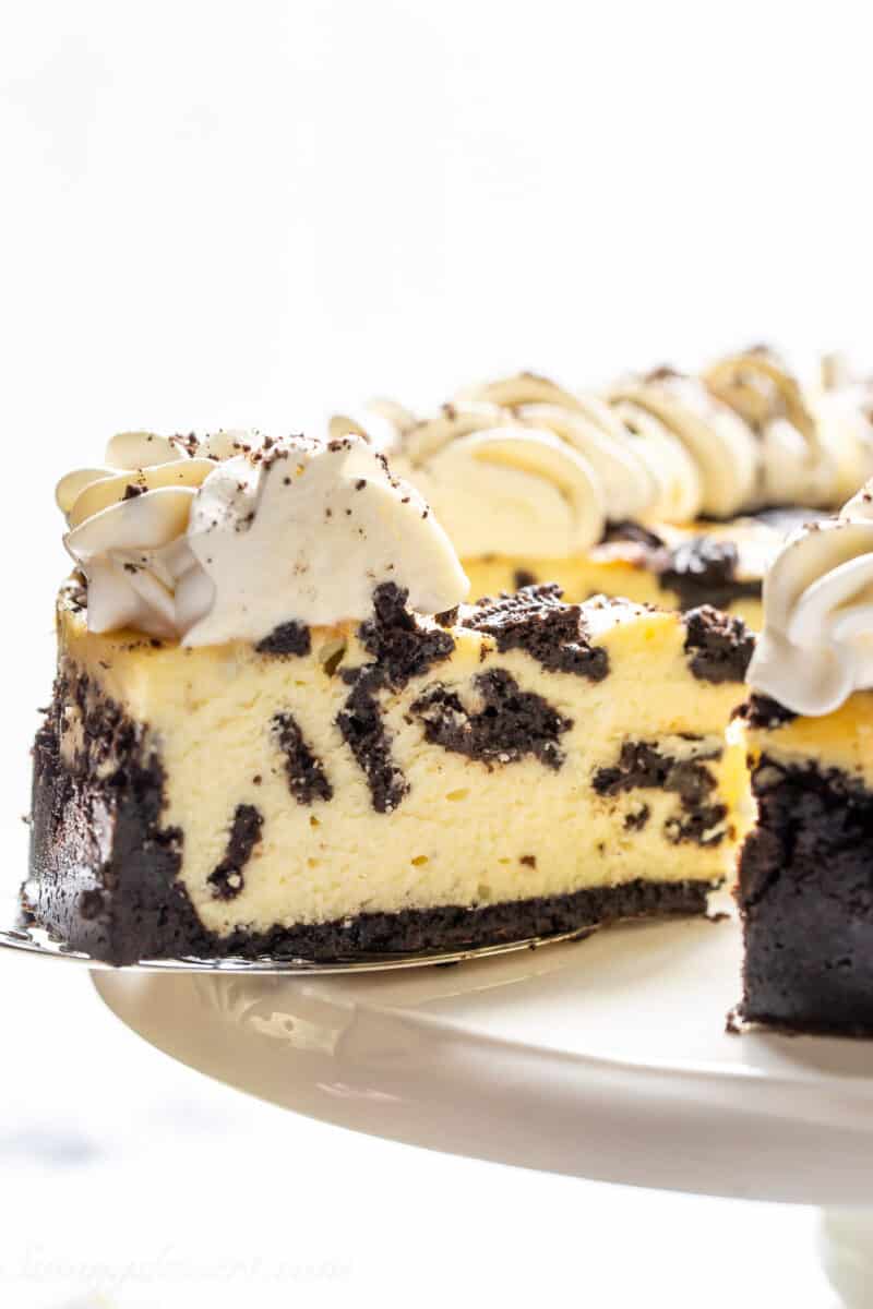 a side view of a slice of cheesecake filled with chopped oreos