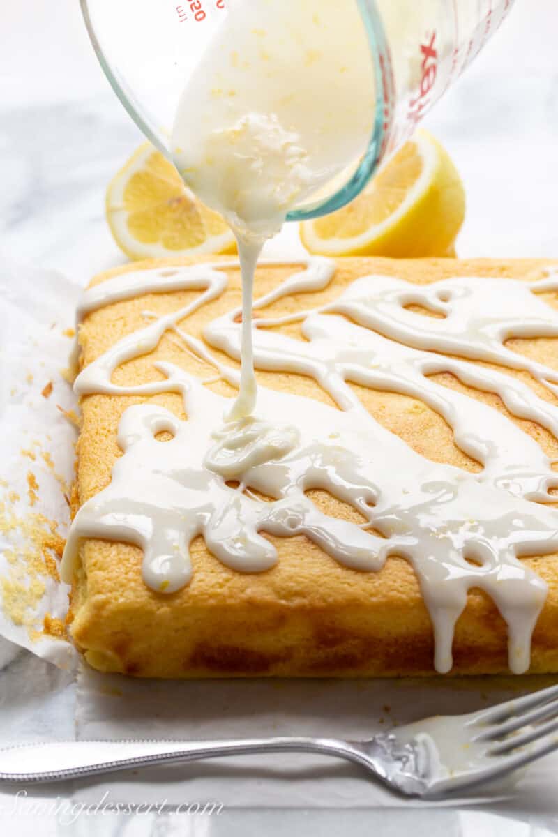 lemon brownies being drizzled with lemon icing