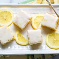 overhead view of a small platter with lemon brownies topped with lemon icing