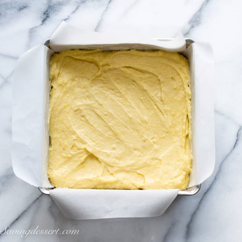 lemon brownie batter spread in a square pan