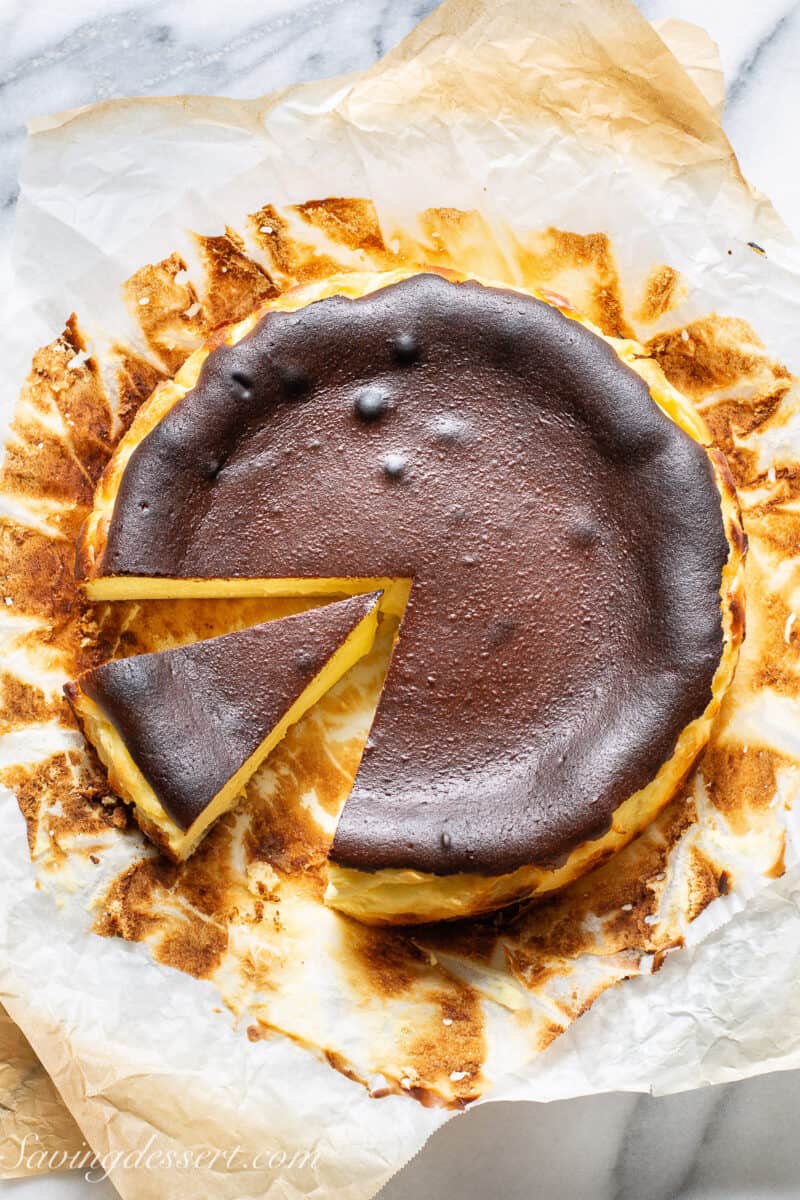 an overhead view of a sliced basque cheesecake set on parchment paper