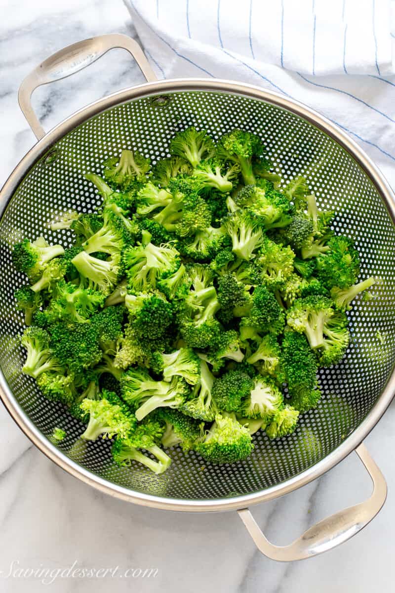 a stainless strainer filled with broccoli florets