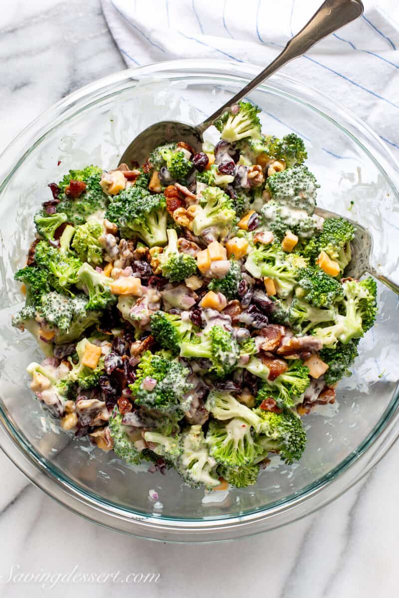overhead view of a bowl of broccoli salad with cheese, bacon and raisins