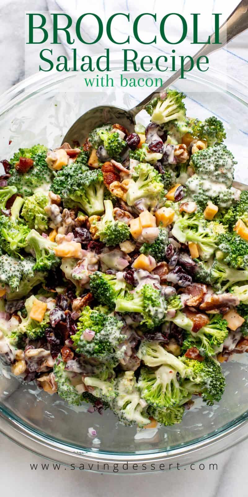 a large bowl of broccoli salad tossed in a tangy dressing with bacon, craisins, onion and walnuts