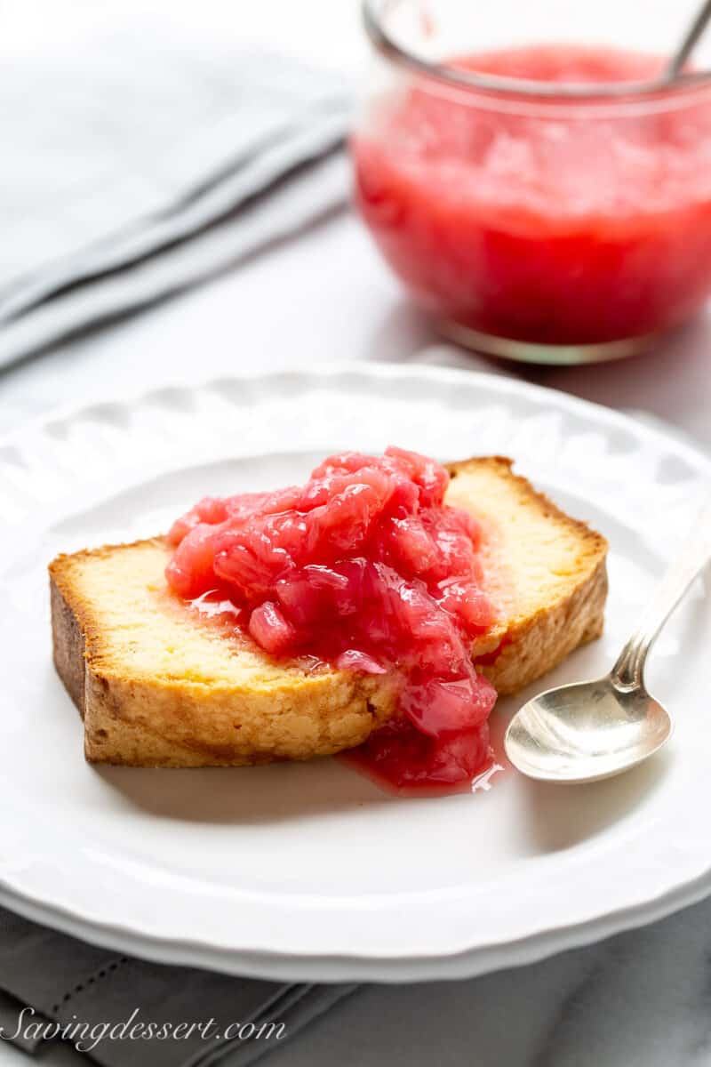 a slice of pound cake with chunky rhubarb sauce poured over the top