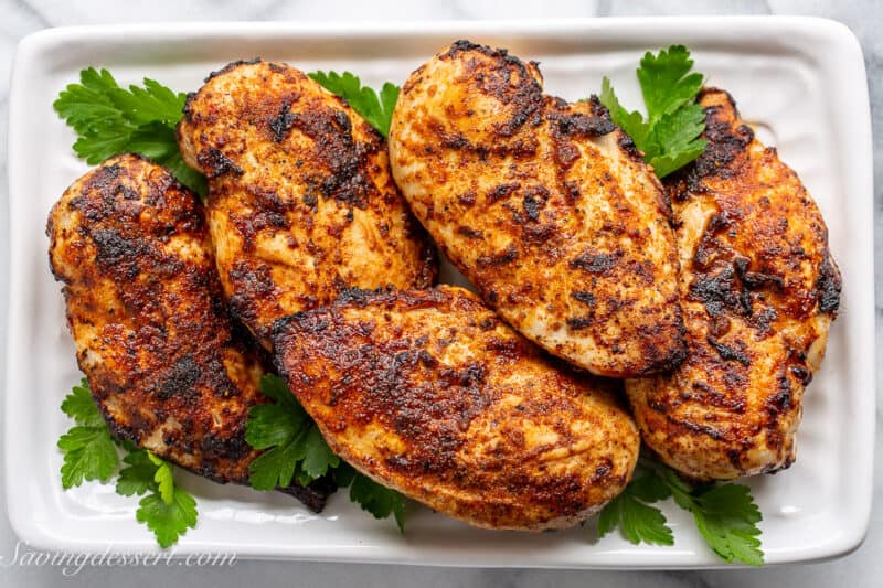 a platter filled with air fryer chicken breasts coated in rotisserie chicken seasoning