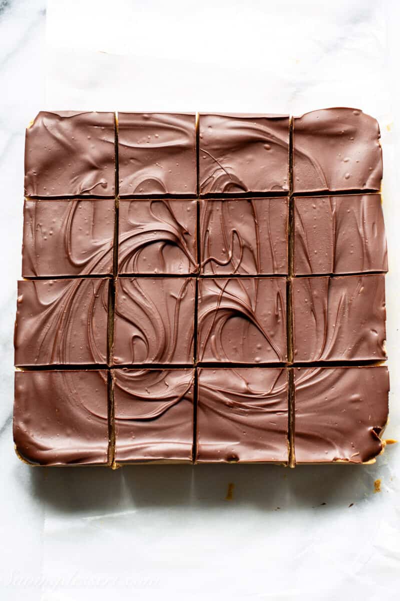 a square pan of peanut butter bars topped with chocolate then cut into squares
