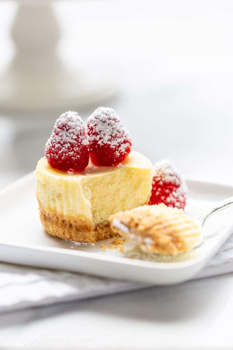 a mini raspberry cheesecake on a plate with a fork