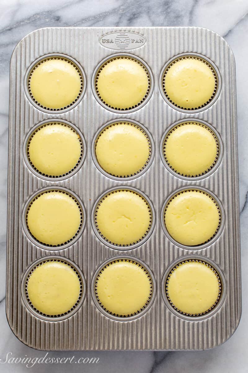 puffed mini cheesecakes in a muffin tin fresh from the oven