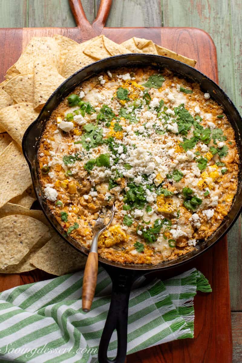 Skillet filled with hot corn dip with chips