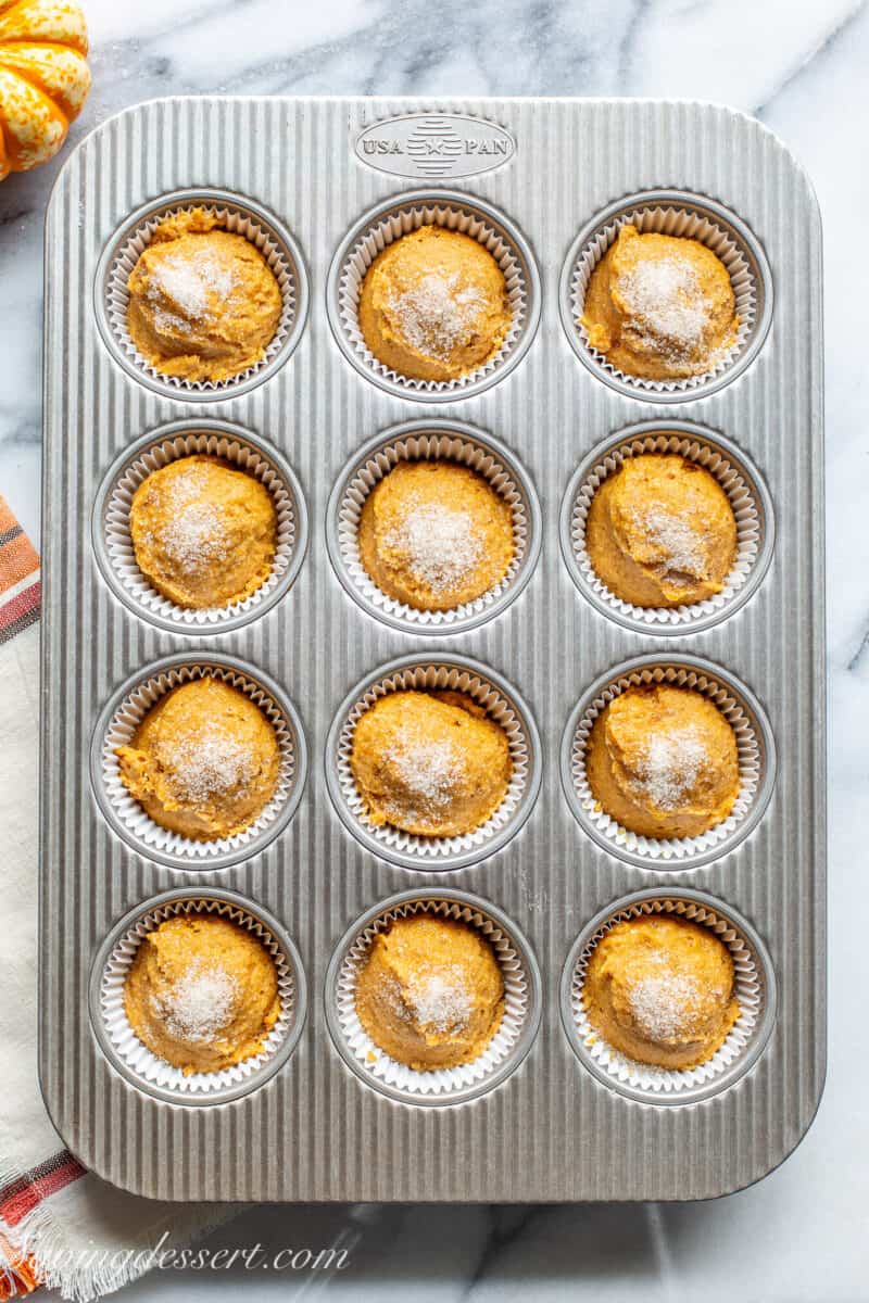 An overhead view of a pan filled with muffin batter ready to go in the oven.