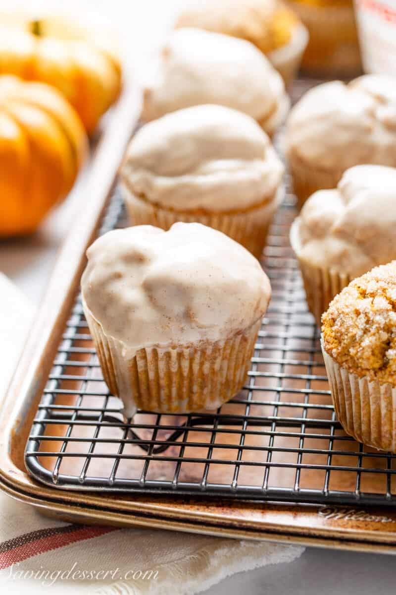 Pumpkin muffins dipped in a glazed drying on a wire rack.