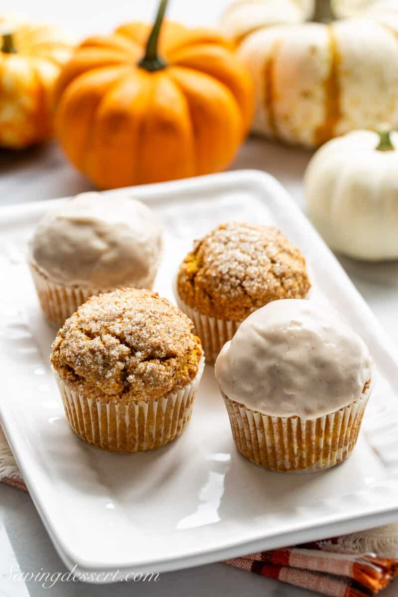 A small platter of pumpkin muffins with mini pumpkins in the background.