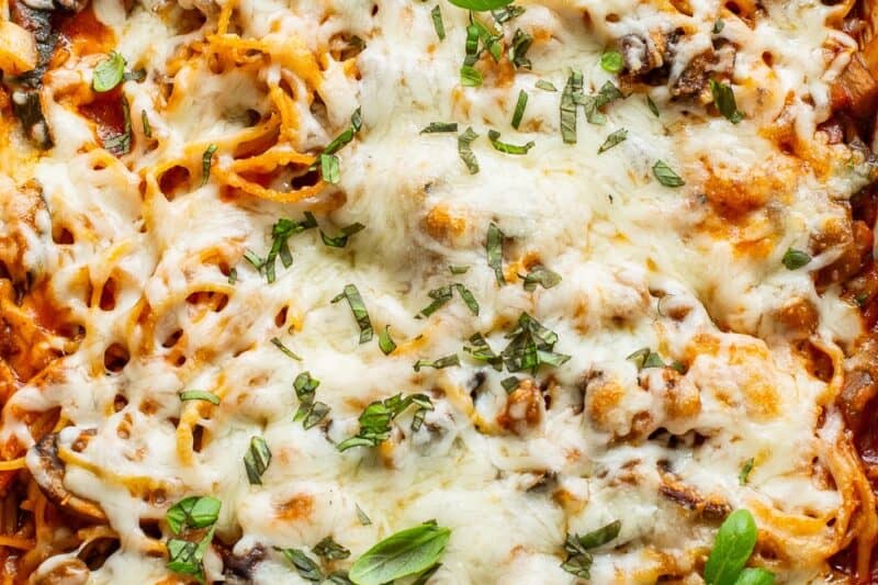 A baked casserole of vegetables, spaghetti, marinara and cheese.