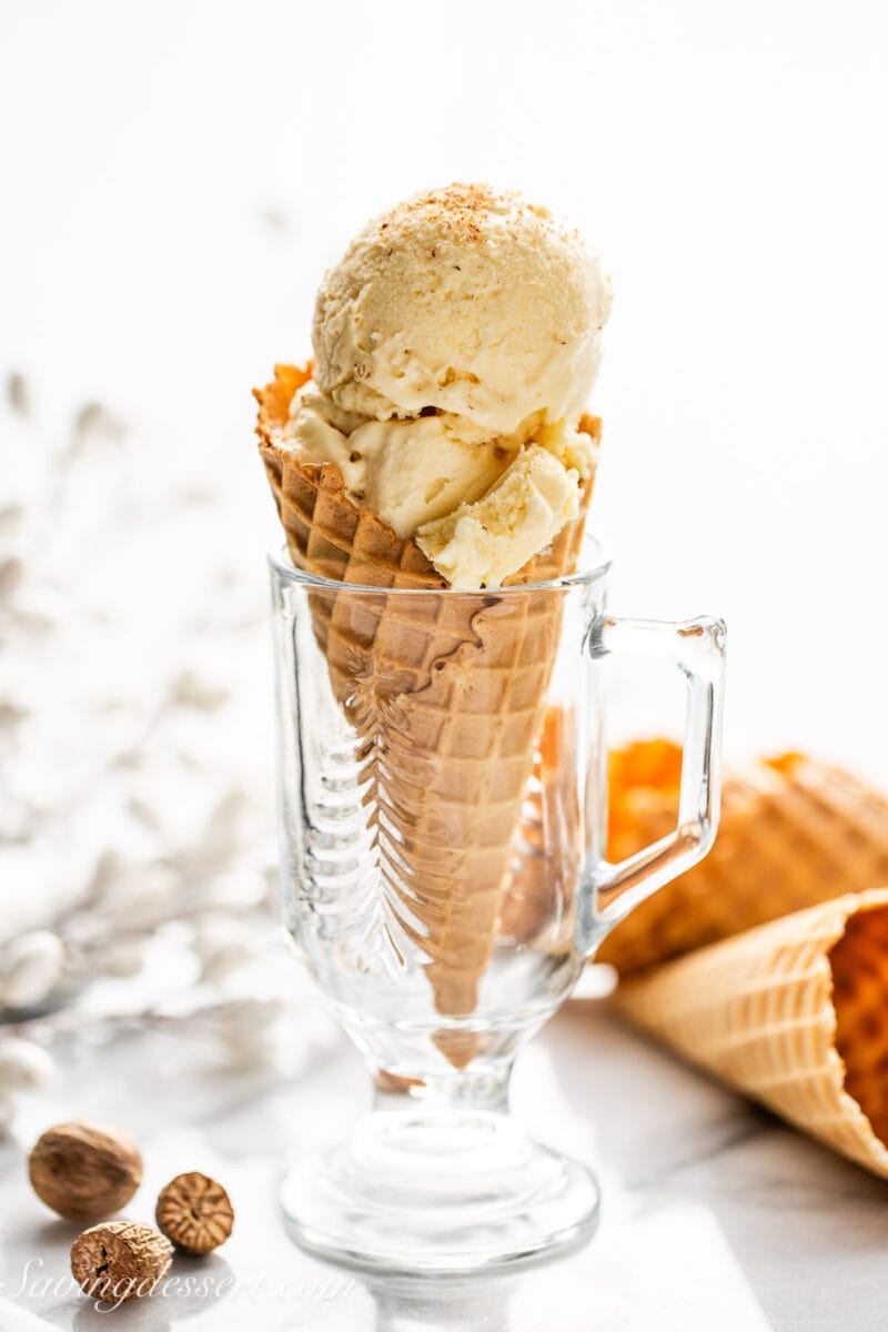 An ice cream cone filled with eggnog ice cream set inside a glass.